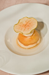 top view, close distance of a dessert of a slice of green apple vanilla ice cream and a half orange , soaked in vodka