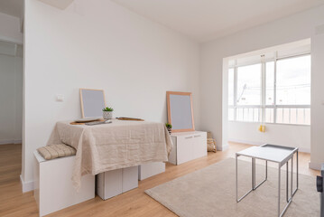 Living room with dining table with linen tablecloth and glazed terrace