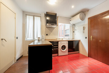 Apartment kitchen with dark wood furniture and red ceramic floors
