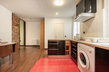 Kitchen with dark wood cabinets, mixed wood and red tile flooring in vacation rental apartment