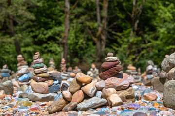 stones laid in a pyramid on the river bank near the forest