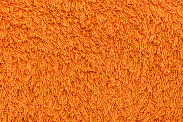 The texture of a towel in orange color close-up. Material. Textile