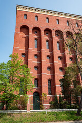 Fototapeta premium Brick building. Red brick wall of a modern building against a bright blue clear sky on a sunny day. High quality photo