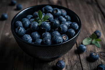 close-up of fresh blueberries in a black bowl on a wooden table. close-up view