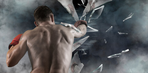 Boxer in red gloves at the moment of impact on glass