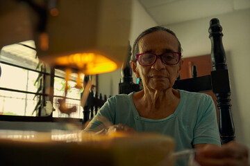 primerplano de mujer anciana colombiana cosiendo prenda de vestir en una maquina  - obrazy, fototapety, plakaty