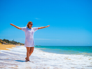 Fototapeta na wymiar Woman walking on sunny beach