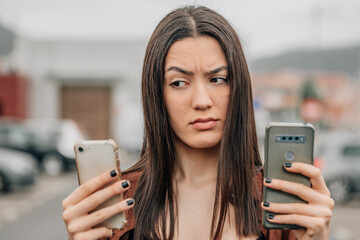 distrustful girl looking at mobile phone - obrazy, fototapety, plakaty