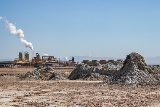 Mud pots at Salton Sea with geothermal generating plant in the background