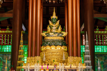 Emerald Buddha, dressed in gold, meditating on a lotus base. at Wat Phra Kaew Chiang Rai - obrazy, fototapety, plakaty