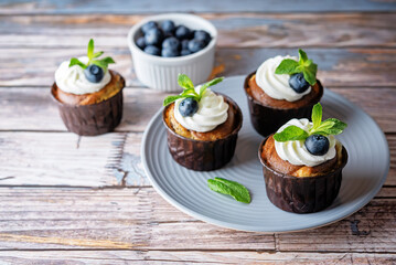 Chocolate cream cheese cupcakes with whipped cream, mint leaves and fresh blueberry
