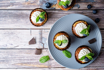 Chocolate cream cheese cupcakes with whipped cream, mint leaves and fresh blueberry