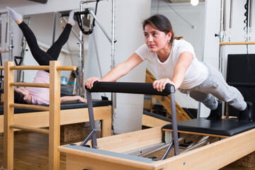 Positive woman practicing pilates in studio