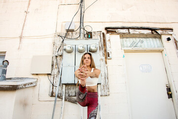 Fit woman balancing behind the yoga studio. 