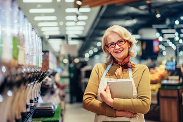 Confident mature owner standing in a grocery store