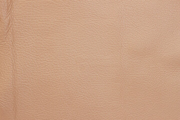 Fototapeta premium Texture of genuine leather close-up, surface close-up with wrinkles and cracks, beige brown color print