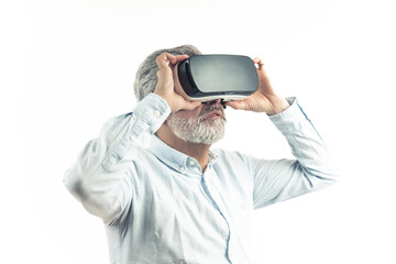 Virtual Reality concept. Caucasian middle-aged gray-haired man in a shirt wearing professional VR goggles and touching them in amazement. Isolated over white background. High quality photo