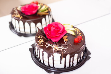 
Chocolate cake with berries, fruits and nuts, decorated with pink rose
