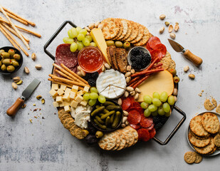 Overhead of charcuterie board of cheese, meat, crackers and fruit.