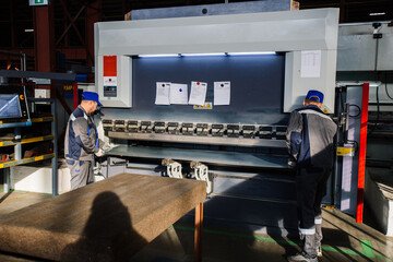 Technician operators working with with sheet metal on CNC hydraulic press brake - obrazy, fototapety, plakaty