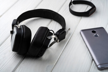 Gadgets on the table. Phone, headphones and fitness tracker on the table
