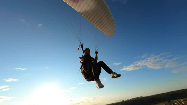 Alone paraglider flying against the colorful sunset, sunrise sky 