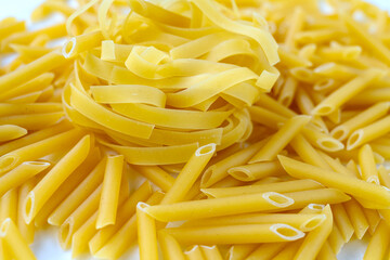 Raw organic dry pasta is ready to cook. Raw Italian pasta on a white background. Paste nest.