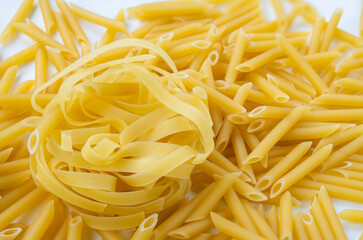 Raw organic dry pasta is ready to cook. Raw Italian pasta on a white background. Paste nest.