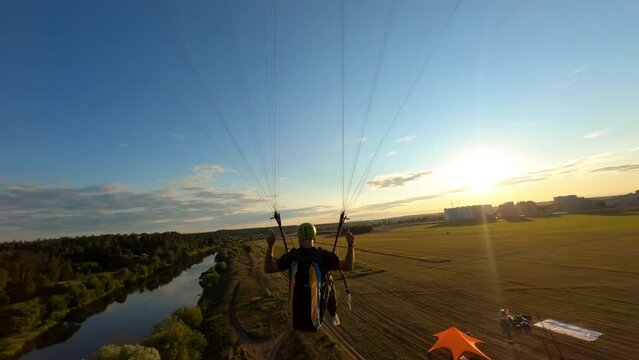 Aerial shot of paraglider flying along the river drone flies above his head
