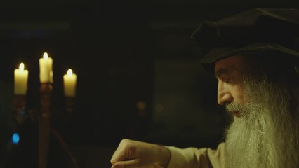 Old man or duplicate of LEONARDO DA VINCI writing , painting , working with divider in vintage designed room . Big drawing of famous artwork . Using , turning compass in Slow motion . 15 -16th century