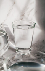 Sunlight through glass of water make light and shadow make a beautiful pattern by refraction of light on white background.