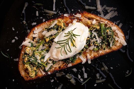 P&atilde;o r&uacute;stico artesanal com espinafre, queijo mussarela burrata decorado com alecrim e queijo parmes&atilde;o. Food styling. Dark photography.