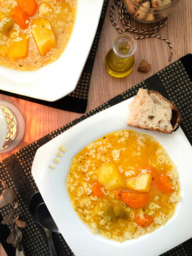 Jantar rom&acirc;ntico com a palavra amor soletrada em sopa de letrinhas, acompanhada de legumes e p&atilde;o r&uacute;stico artesanal.