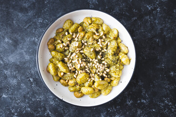 healthy plant-based food, vegan green pesto gnocchi with white beans and pine nuts