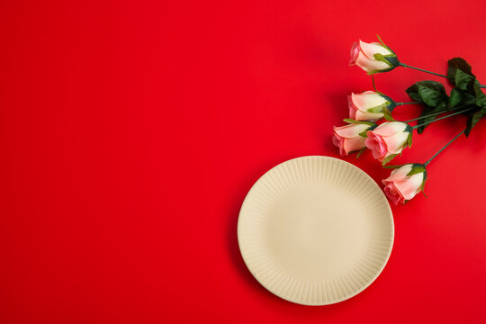 赤いテーブルに置かれたバラとお皿　background	