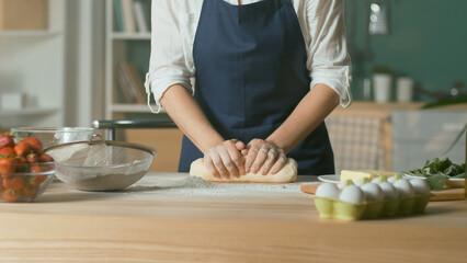 Professional Chef Kneads Dough for Baking on a Wooden Kitchen Table. The Process of Making a Beautiful Dough. Homemade Cakes for a Pastry Coffee Shop. Close-up.