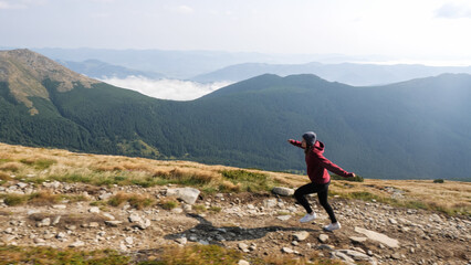 Woman is climbing a mountain ridge. Woman going through a stone valley in mountain