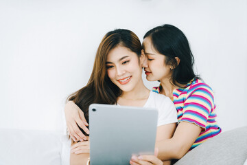 lgbtq, lgbt concept, homosexuality, portrait of two asian women posing happy together and loving each other while playing tablet on bed
