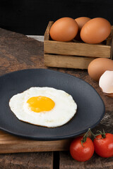 Delicious fried egg on black plate.
