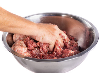 Close-up of a woman's hand kneading ground beef in a bowl - isolated on white background