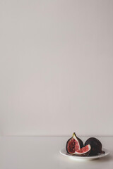 Fresh figs on the plate on grey background. Two figs minimalism.
