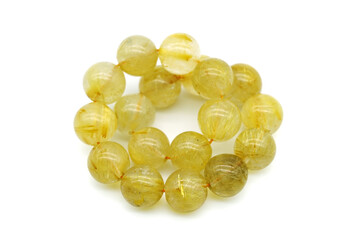 Fototapeta premium Rutile in quartz gemstone on rock background. Rutile quartz stone beads.