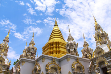 Fototapeta na wymiar Gold yellow pagoda on bright blue sky cloud at Sri Don Mun Temple, Chiang Mai, Thailand