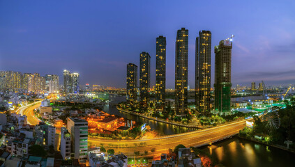 Naklejka premium Aerial view of Bitexco Tower, buildings, roads, Thu Thiem 2 bridge and Saigon river in Ho Chi Minh city - Far away is Landmark 81 skyscraper. Travel concept.
