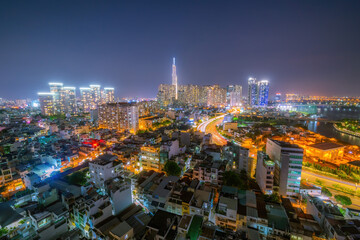 Fototapeta na wymiar Aerial view of Bitexco Tower, buildings, roads, Thu Thiem 2 bridge and Saigon river in Ho Chi Minh city - Far away is Landmark 81 skyscraper. Travel concept.