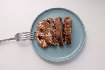 Homemade mosaic chocolate biscuit cake served in a blue plate, selective focus. It is called "Mozaik Pasta" in Turkish. That is texture of it not grain. Traditional Turkish dessert.