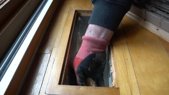 Slow motion of dust and dirt being hand removed from an air conditioning floor duct