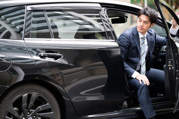 Fototapeta na wymiar 車から降りる男性　ビジネスマン　スーツ