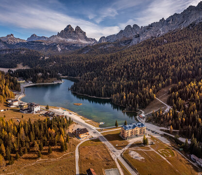 Misurina, Auronzo, Italy - Aerial view of Lake Misurina in the Italian Dolomites on an autumn morning with Tre Cime di Lavaredo peaks (Three Merlons), autumn foliage and blue morning sky and clouds