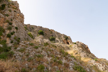 Fototapeta na wymiar Overgrown with small crooked trees, grass and bushes, the slope of Mount Arbel, located on the shores of Lake Kinneret - the Sea of Galilee, near the city of Tiberias, in northern Israel.